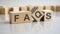 word Faqs on wooden cubes, gray background