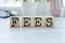 word FEES on wooden cubes on blue background. the inscription on the cubes is reflected from the surface. business