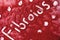 The word Fibroids written in red glitter