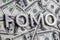 The word FOMO laid with aluminium letters on the US dollar banknotes background - with selective focus