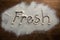 The word fresh written on sprinkled flour