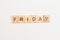 Word FRIDAY made from wooden cubes on white. Days of the week