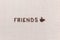The word friends next to a coffee mug both made from coffee beans,aligned in the center
