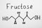 Word Fructose with drawn scheme on paper, top view