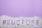 Word Fructose made of sugar on violet background, top view. Space for text