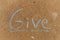 The word Give written with sidewalk chalk on gray concrete pavement background