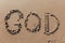 The word `God` on the sea sand, written with stick on the beach.