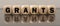 The word grants on wooden cubes with a reflection on a black background