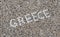 The word Greece made of shells on beach in the sand.