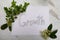 The word growth handwritten on white paper with green organic rustic foliage background texture