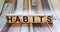The word habits is written on wooden cubes that lie