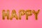 Word HAPPY made of golden foil balloons letters on background