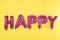 Word HAPPY made of pink foil balloons letters on background