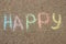 Word happy written in colored crayons on the road