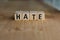 Word of HATE spelled with colorful wooden alphabet blocks.