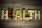 The word health written with fruits on a wooden background.