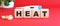 The word HEAT is made of wooden cubes on a red background. Medical concept