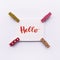 Word hello handwritten with watercolor in calligraphy style, miniature clothespins on a white background. Flat lay