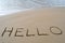The word Hello written in the sand