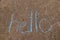 The word Hello written with sidewalk chalk on gray concrete pavement background
