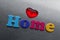 Word home with red heart spelled out using colored fridge magnet