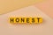 The word honest written on yellow cubes close up.