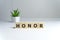 The word Honor written in vintage wooden cubes on a white background