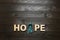 Word Hope made of letters and teal awareness ribbon on wooden background, top view. Symbol of social and medical