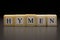 The word HYMEN written on wooden cubes, isolated on a black background