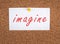 The word imagine is standing on a pinned paper, creative concept, futuristic dream, story telling