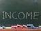 The word Income written in chalk