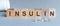 The word insulin wooden cubes with black letters, hormone insulin, diabetes treatment gray background front view, In front of a