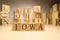 The word Iowa was created from wooden letter cubes. Cities and words.