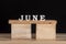 Word June by wooden letters. Black background. Month name. Summer calendar