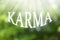Word KARMA on blurred green background, bokeh effect