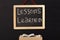 Word lessons learned written on miniature chalkboard