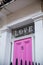 Word Love above the pink door of a white British house
