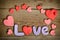 Word Love composition on the wooden board with hearts