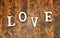 Word LOVE on dark wooden background