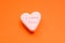 Word love in English on a candy heart, sweet image for Valentine`s Day, isolated on red background