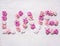 Word love made of paper roses, decorations for Valentine\'s Day wooden white rustic background top view close up