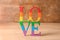 Word LOVE made of rainbow letters on wooden table. LGBT concept