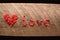 The word love made with red sewing buttons on wood