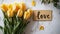 the word "Love" placed next to a beautifully arranged bouquet of tulips on a light background, blending modern