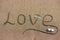 Word love on sand background