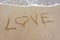 The word love in the sand on the beach.