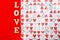 Word LOVE using wooden letters on red and hearts Valentines design