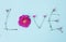 Word LOVE written with carnation and wild rose flowers