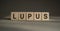 The word lupus from wooden cubes on gray background