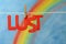 The word lust with a blue sky and colorful rainbow background.